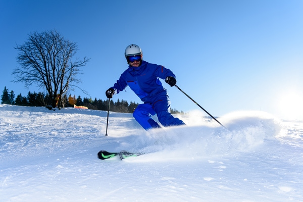 Mann fährt Ski mit Skistöcken